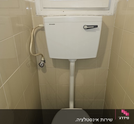 אסלה עם מיכל הדחה בחדר שירותים קטן